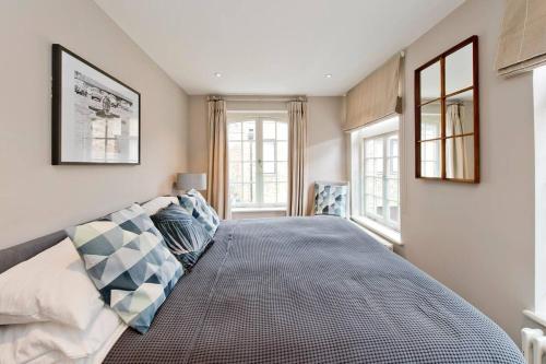 1 dormitorio con 1 cama grande y 2 ventanas en *Newly Renovated 2-Bed in Heart of Notting Hill*, en Londres