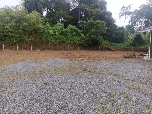an empty yard with a fence and trees at Jeli Heights Hill Homes in Jeli