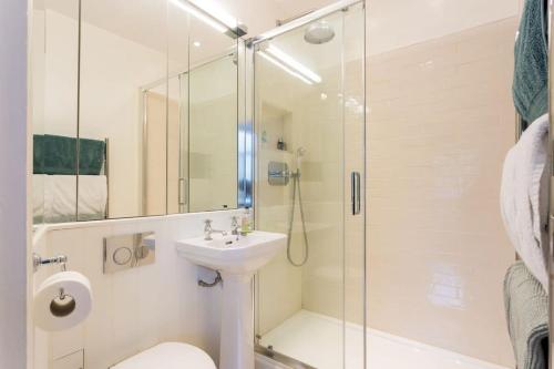 y baño con ducha, aseo y lavamanos. en Artistic 1bed flat with patio in South Kensington, en Londres