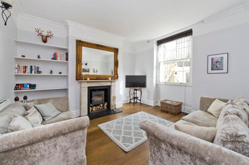 a living room with two couches and a fireplace at Charming 2-Bed Apt, Pimlico in London