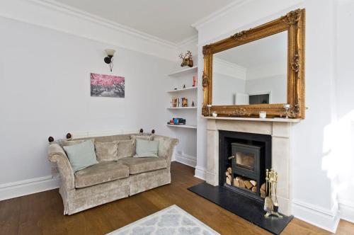 a living room with a couch and a mirror at Charming 2-Bed Apt, Pimlico in London