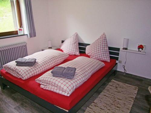 a bedroom with two beds with red and white pillows at Haus Elisabeth - Fewo Glottertal, 1 Schlafzimmer, Feldberg nahe Skipiste in Neuglashütten