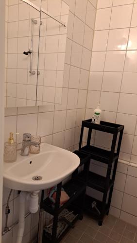 ein weißes Bad mit einem Waschbecken und einer Dusche in der Unterkunft Room in apartment in Malmö