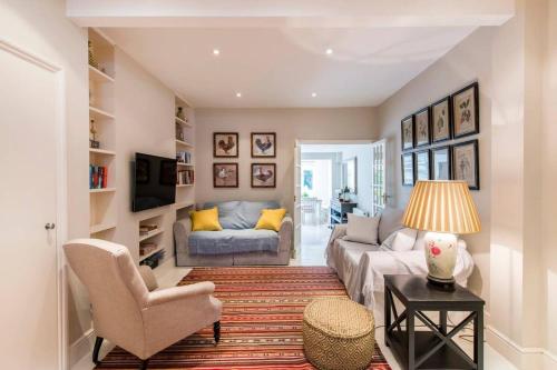 uma sala de estar com um sofá e uma mesa em Delightful 2 Bed House in Stylish Fulham em Londres