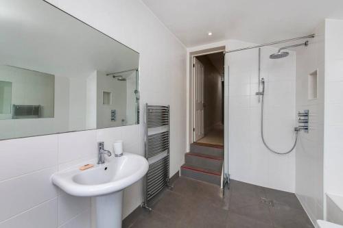 uma casa de banho branca com um lavatório e um chuveiro em Delightful 2 Bed House in Stylish Fulham em Londres