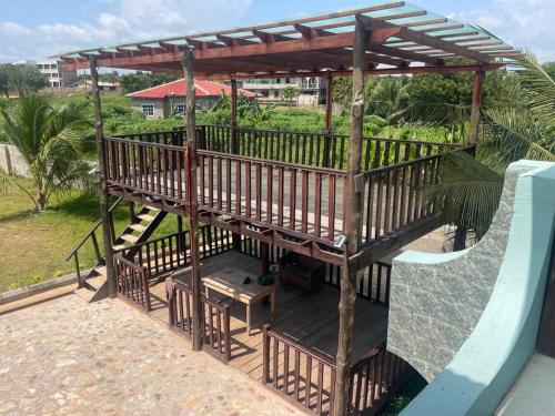 a wooden deck with a gazebo and a slide at THE GREEN CONDO in Elmina