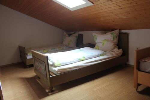 un piccolo letto in una camera con soffitto in legno di Haus Elisabeth - Ferienwohnung Tannenwipfel, 1 Schlafzimmer, Feldberg a Neuglashütten