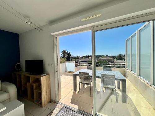 une chambre avec un balcon avec une table et des chaises dans l'établissement Calypso, appartement Vue mer, à La Ciotat