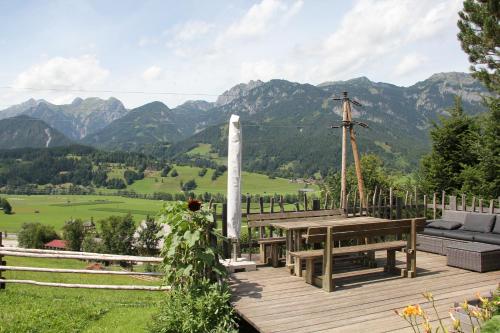 a wooden deck with a table and a view of mountains at Ferienhaus Ennsling in Haus im Ennstal