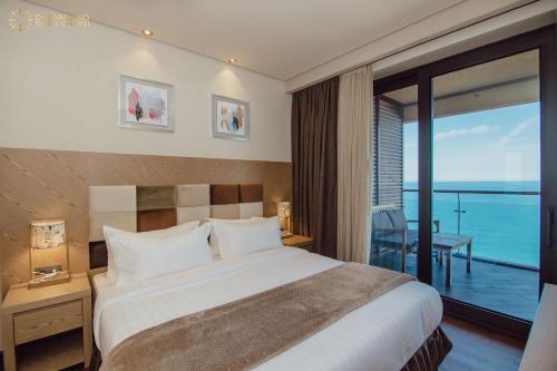 a bedroom with a bed with a view of the ocean at Dreamland Oasis Aparthotel in K'obulet'i