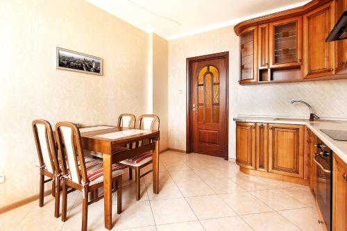 a kitchen with a table and chairs and a sink at Apartment in Complex Korona on Knyazhyi Zaton 21 in Kyiv