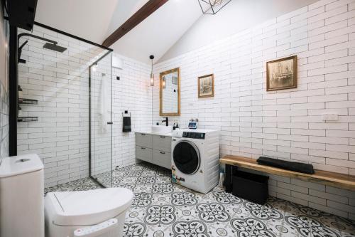 a bathroom with a toilet a sink and a washing machine at Heritage Log Cabin and Garden w Outdoor Hot Tub in Medlow Bath