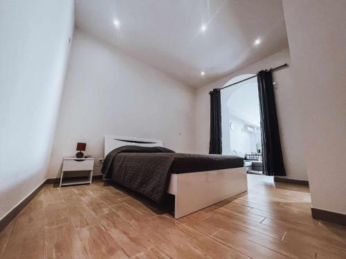 une chambre avec un lit et une grande fenêtre dans l'établissement Appart cosy, à Sartène