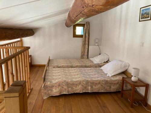 een slaapkamer met een bed en een houten vloer bij Maison au Colorado Provençal in Rustrel