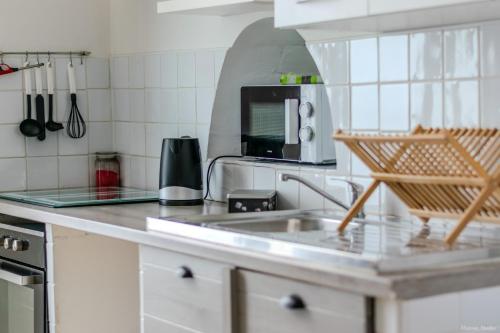 une cuisine avec un évier et un micro-ondes dans l'établissement Appart cosy, à Sartène