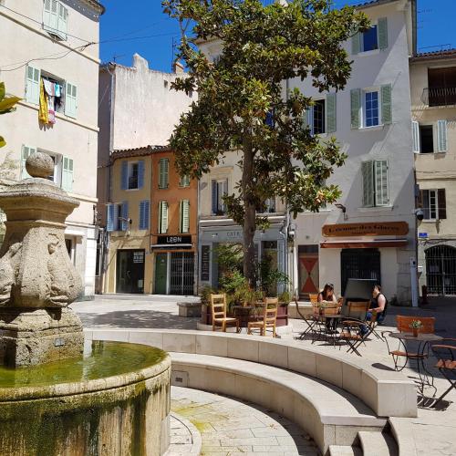 une fontaine au milieu d'une rue avec des bâtiments dans l'établissement JOLI STUDIO CLIMATISE PROXIMITE PORTS ET PLAGES, à La Ciotat