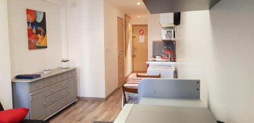 une petite cuisine avec une table et une armoire dans l'établissement JOLI STUDIO CLIMATISE PROXIMITE PORTS ET PLAGES, à La Ciotat