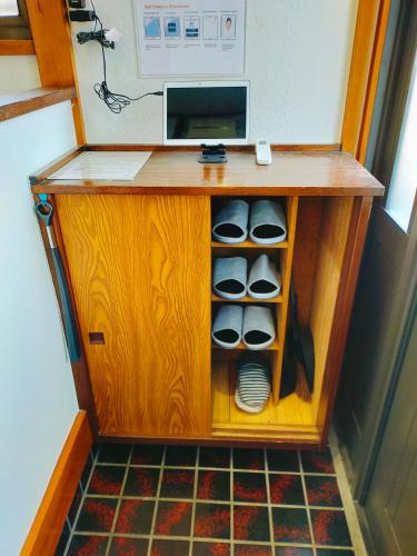 a wooden desk with a microwave on top of it at 15min to Haneda Airport - Homies House Kamata for up to 9 guests in Tokyo