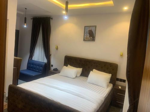 um quarto com uma cama e uma cadeira azul em BLUE AO HOTEL em Lagos