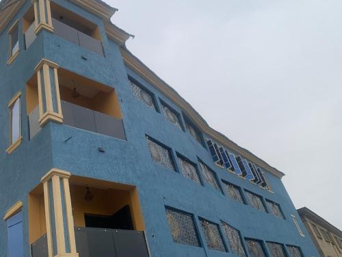 a blue building with yellow windows on the side of it at BLUE AO HOTEL in Lagos