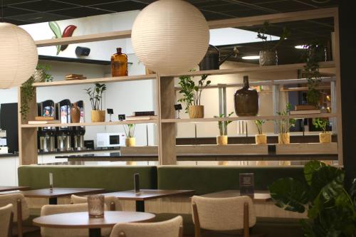 un restaurant avec des tables, des chaises et des plantes en pot dans l'établissement Smarthotel Oslo, à Oslo