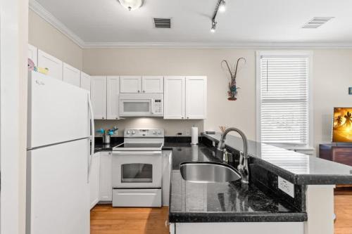 a kitchen with a sink and a white refrigerator at Mesa House, Dos -Unreal Location in Key West