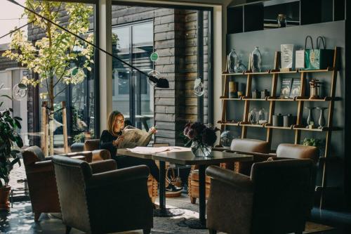 a woman sitting at a table in a room at Sigtunahöjden Hotell & Konferens in Sigtuna