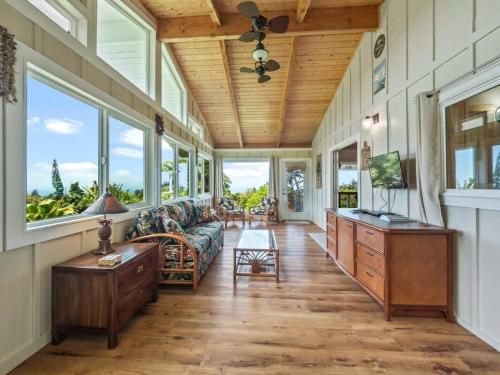 a living room with a couch and windows at South Kona Farm House on 22 Acres in Milolii in Papa Bay Estates