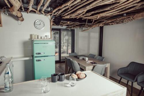 een keuken en eetkamer met een klok aan de muur bij Hausboot Iron Franz- Entspannung auf dem Wasser in Düsseldorf