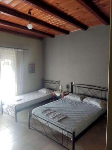 a bedroom with two beds and a window at Venus cottage in Agios Vlasios