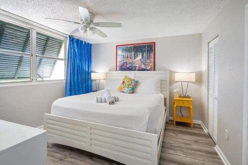 um quarto com uma cama branca e uma ventoinha de tecto em The Andros by Brightwild-4th Floor Sunset View em Key West