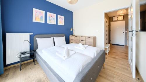 een slaapkamer met een groot bed met een blauwe muur bij Apartamenty Sun & Snow Villa Verona in Mielno