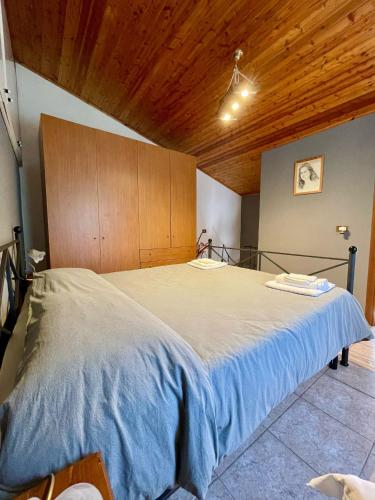 Sesta Godano的住宿－卡薩度假瑪日薩旅館，一张位于带木制天花板的客房内的大床