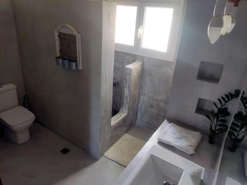 een badkamer met een toilet, een wastafel en een raam bij ''Venus'' in Agios Vlasios