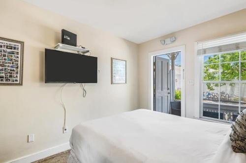 a bedroom with a white bed and a flat screen tv at Sea Breeze -Great Location! in Key West