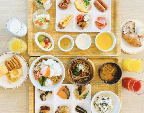 a table with plates of food and bowls of food at Hotel JAL City Nagano in Nagano