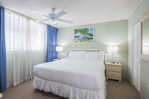 1 dormitorio con cama blanca y ventilador de techo en The Salt Cay by Brightwild-Modern & Pet Friendly, en Key West