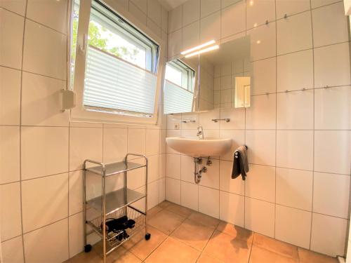une salle de bain avec un lavabo et un miroir dans l'établissement Haus Villa am Meer, An der Rennweide 20, à Dangast