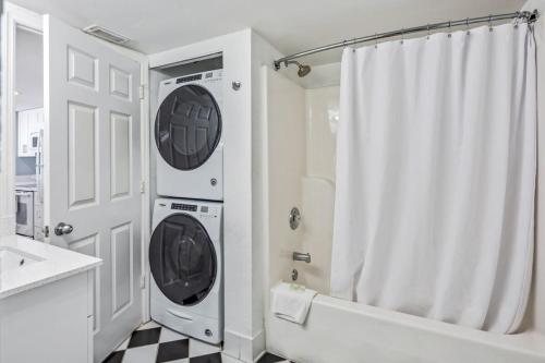 a white bathroom with a washer and dryer in it at The Salt Cay by Brightwild-Modern & Pet Friendly in Key West