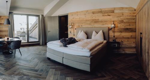 - une chambre avec un grand lit et un mur en bois dans l'établissement THE MATTHEW - pop up & down, à Wagrain