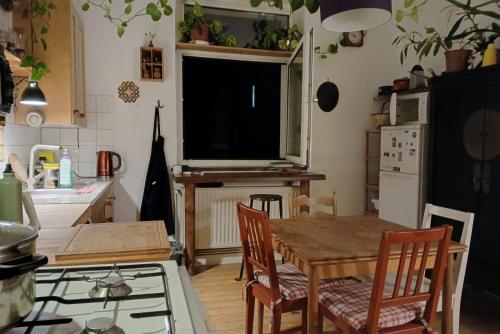 a kitchen with a table and a television on the wall at Private Rooms in Hannover