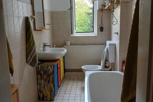 a bathroom with a sink and a toilet and a window at Private Rooms in Hannover