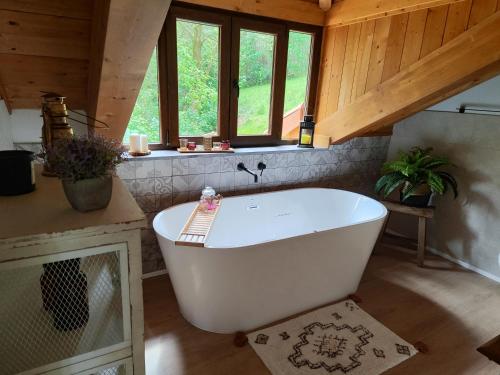 a large white bath tub in a room with windows at Reguero Gato Turismo Rural in Candamo
