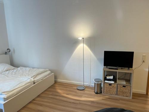 een slaapkamer met een bed en een flatscreen-tv bij Messewohnung für 2 in Giesen
