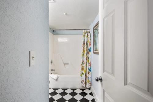 a bathroom with a black and white checkered floor at The Exuma Cay by Brightwild-Pool View & Parking in Key West
