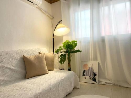 a bedroom with a bed with a plant and a lamp at Sinchon Property in Seoul