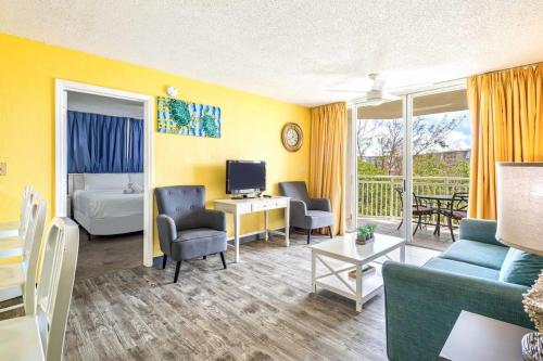 a living room with a couch and a bed and a television at Tortuga Suite at Sunrise Suites Resort - Heated Pool, Hot Tub & Free Parking in Key West