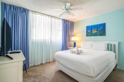 een slaapkamer met een groot wit bed en een televisie bij The Tortuga by Brightwild-Pool, Parking & Pets! in Key West