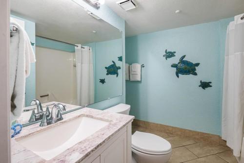 uma casa de banho com um lavatório, um WC e um espelho. em The Tortuga by Brightwild-Pool, Parking & Pets! em Key West