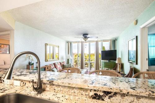 eine Küche mit einem Waschbecken und ein Wohnzimmer in der Unterkunft The Samana Cay by Brightwild-Private Balcony in Key West